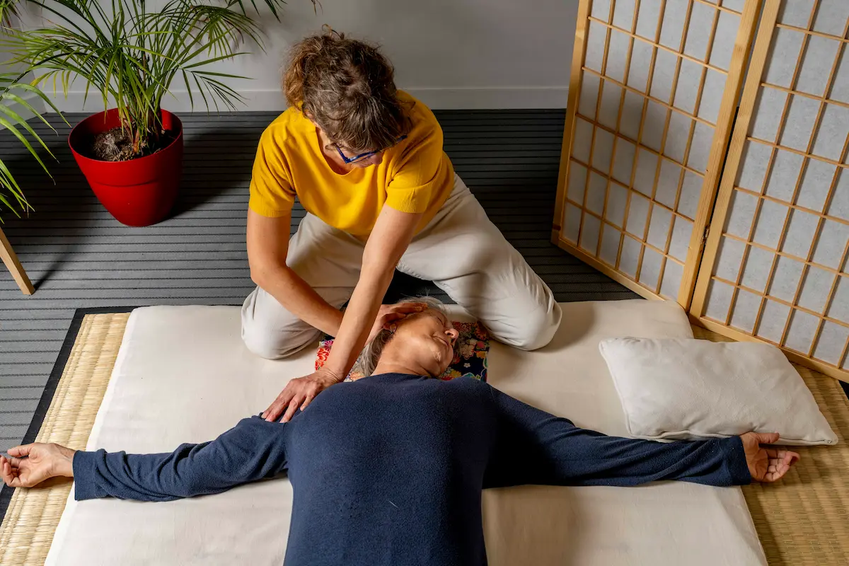 Praticienne de shiatsu Diana Petit Sarkanj travaillant les épaules du cliente, à cabinet Maibe à Caen